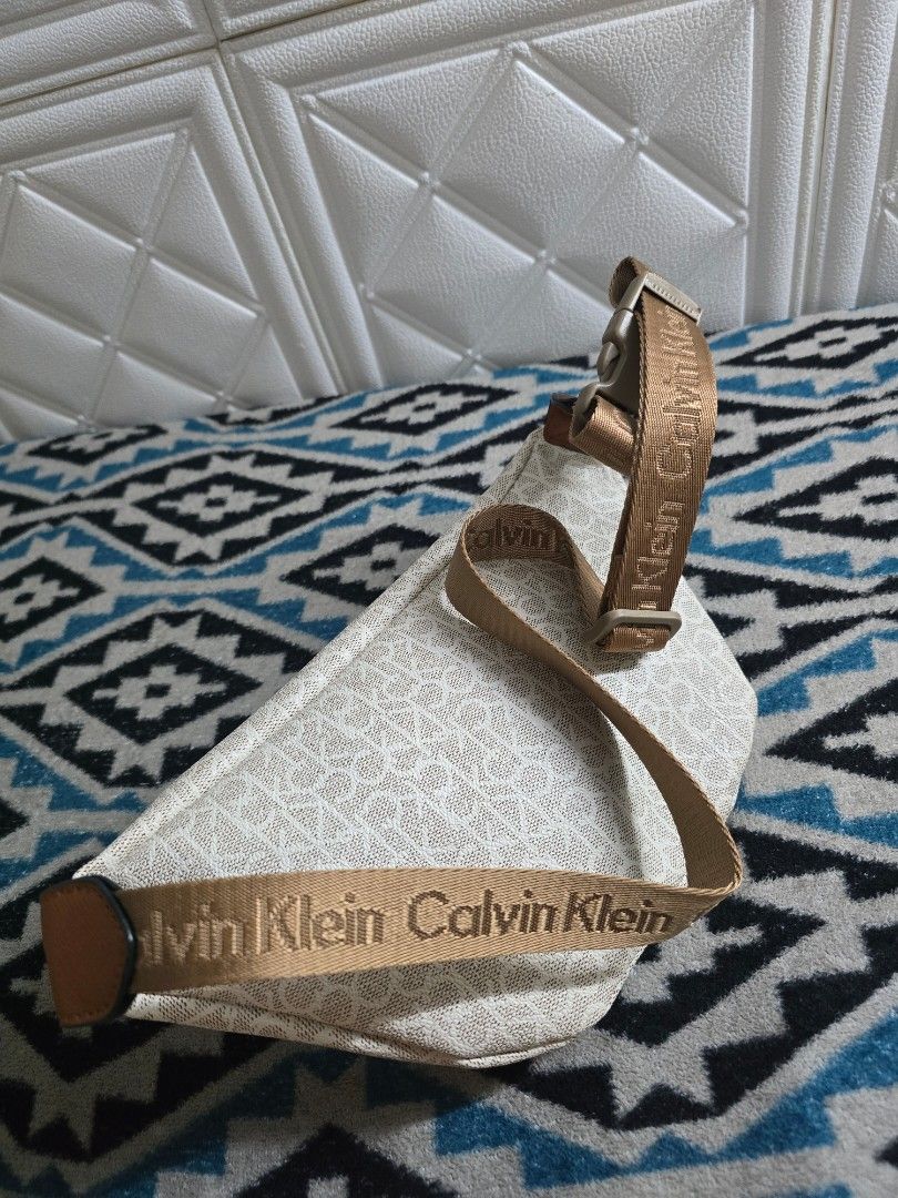Calvin Klein Monogram Belt Bag Fanny Pack (Category: Luxury Bags & Wallets) located in Manila. Submitted by trialfindsmanila (Listing ID 1453414613, Image 2). Description: Barely used Very good condition slightly nego‼️‼️ Rfs: Declutter Delivery via Lalamove or Pick Up Location: Sta. Ana Manila - Authentic White Calvin Klein Belt Bag - All-over CK Monogram Print - Elegant Gold Hardware - Stylish Brown Trim Accents - Adjustable Strap with Calvin K