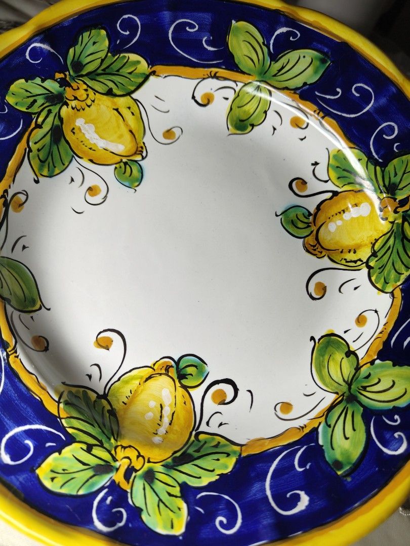 Ceramics Italy Positano Lemon Plate (Category: Dinnerware & Cutlery) located in Zamboanga. Submitted by lunavinum (Listing ID 1453342169, Image 2). Description: - Hand-painted ceramic plate from Italy - Vibrant lemon and leaf design on white background - Blue and yellow border - 9 inches in diameter - Perfect for display or serving - Marked 'CER. MARIAGRAZIA POSITANO ITALY' on the back.