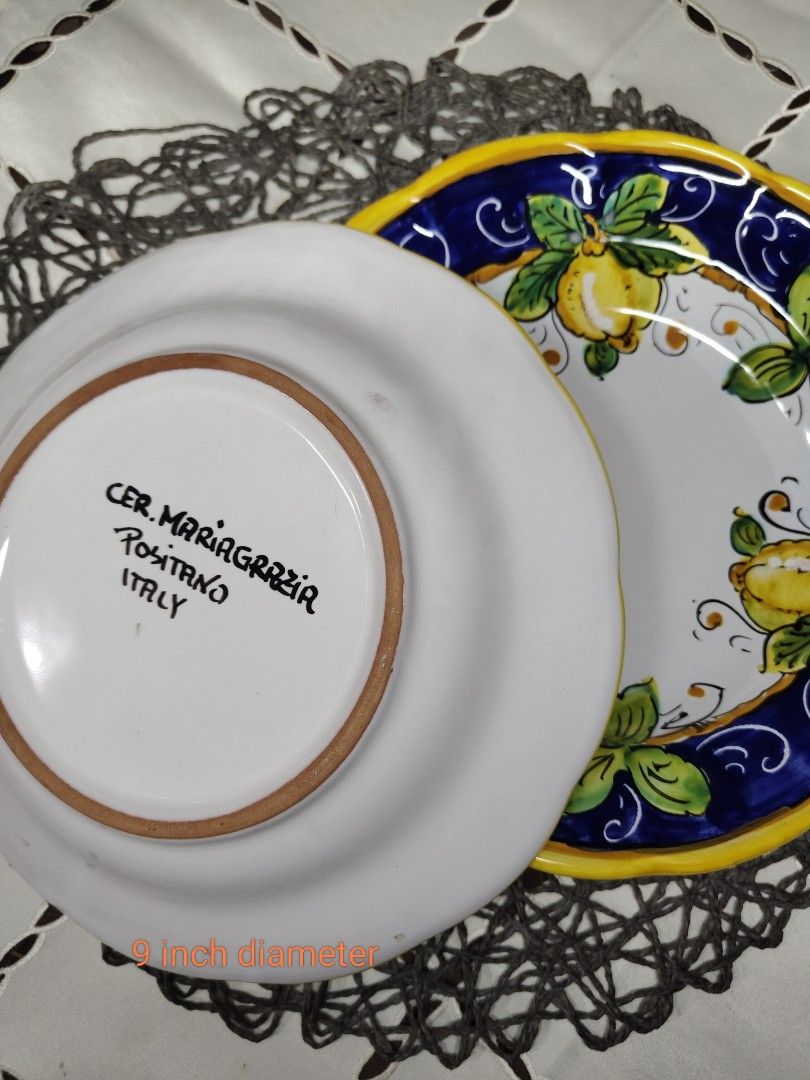 Ceramics Italy Positano Lemon Plate (Category: Dinnerware & Cutlery) located in Zamboanga. Submitted by lunavinum (Listing ID 1453342169, Image 3). Description: - Hand-painted ceramic plate from Italy - Vibrant lemon and leaf design on white background - Blue and yellow border - 9 inches in diameter - Perfect for display or serving - Marked 'CER. MARIAGRAZIA POSITANO ITALY' on the back.