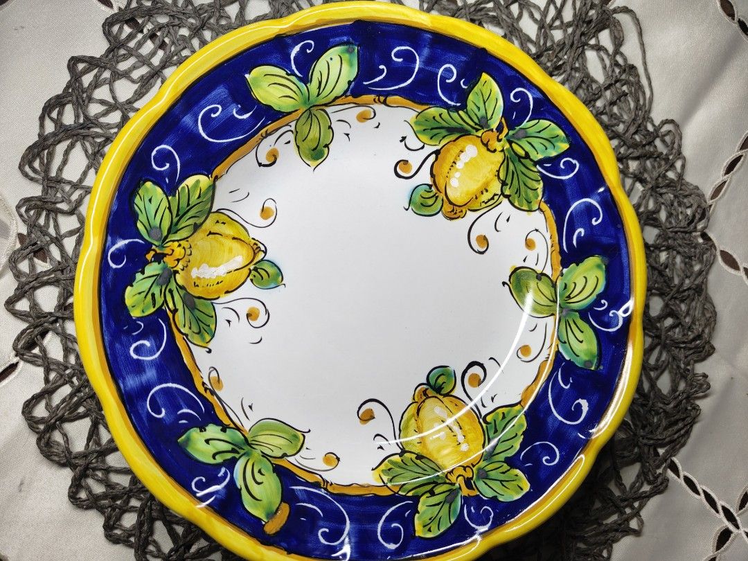 Ceramics Italy Positano Lemon Plate (Category: Dinnerware & Cutlery) located in Zamboanga. Submitted by lunavinum (Listing ID 1453342169, Image 1). Description: - Hand-painted ceramic plate from Italy - Vibrant lemon and leaf design on white background - Blue and yellow border - 9 inches in diameter - Perfect for display or serving - Marked 'CER. MARIAGRAZIA POSITANO ITALY' on the back.