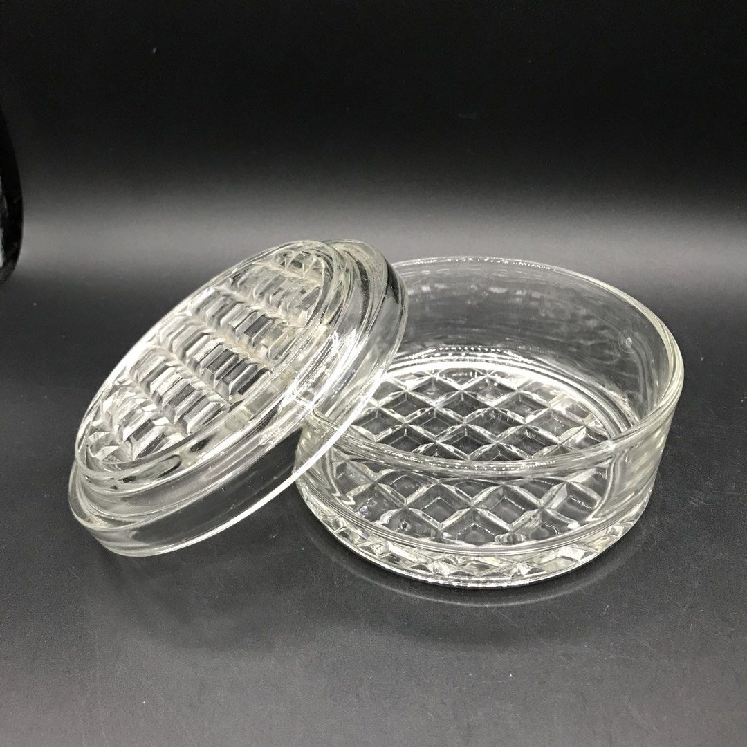Clear Glass Round Container with Lid (Category: Food Organization & Storage) located in Baao. Submitted by all.things.japan (Listing ID 1453401539, Image 1). Description: 4.25 x 2.5 inches - Vintage clear glass round container with matching lid. - Features a beautiful diamond and grid pattern on the base and lid. - Ideal for storing small trinkets, jewelry, or as a charming decorative accent. - Adds a touch of retro elegance to any space..