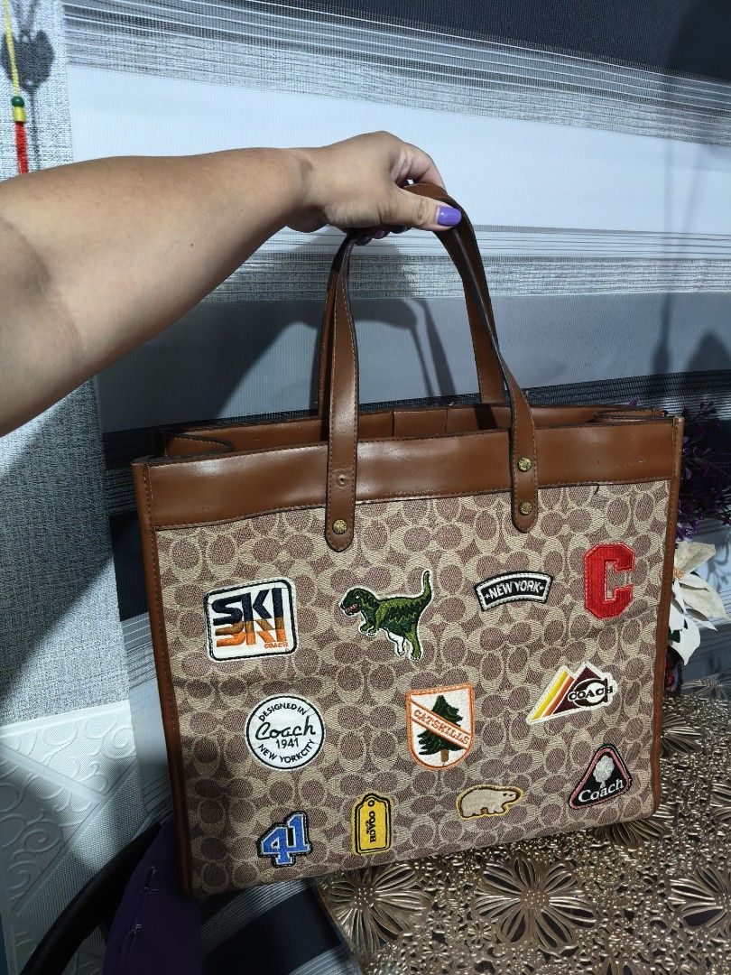 Coach Monogram Tote Bag with Patches (Category: Luxury Bags & Wallets) located in Manila. Submitted by stuff_finder (Listing ID 1453308750, Image 2). Description: Coach tote bag - Signature monogram print - Unique patches: 'Ski', 'New York', dinosaur, and more! - Brown leather trim and handles - Spacious interior, ideal for everyday essentials - Stylish and functional for daily use.