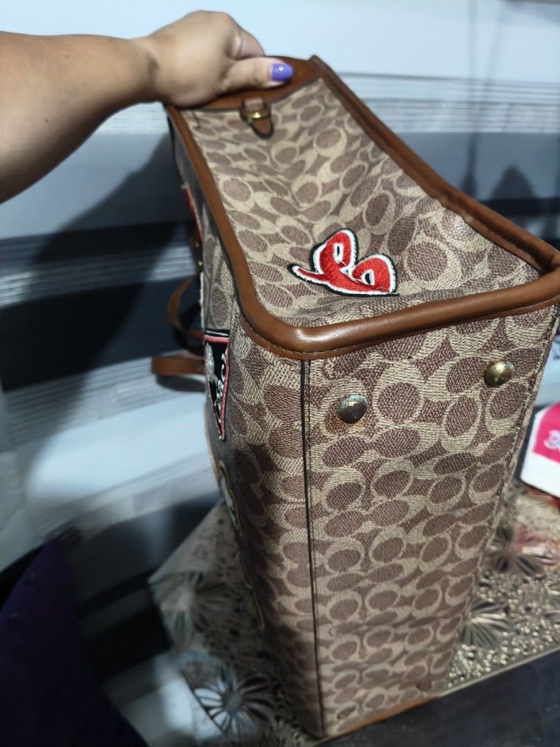 Coach Monogram Tote Bag with Patches (Category: Luxury Bags & Wallets) located in Manila. Submitted by stuff_finder (Listing ID 1453308750, Image 3). Description: Coach tote bag - Signature monogram print - Unique patches: 'Ski', 'New York', dinosaur, and more! - Brown leather trim and handles - Spacious interior, ideal for everyday essentials - Stylish and functional for daily use.