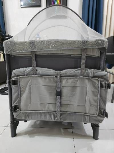 Crib for baby (Category: Cots & Cribs) located in Makati City. Submitted by michellnoz50229 (Listing ID 1453239165, Image 2). Description: Cocobb Baby Crib Standard size (100 x 74 x 70 cm) With Mosquito net Has co-sleeper on one side Color Gray Weight Capacity: - Layer 1 (Crib/Bed): 0 to 36 months - Layer 2 (Bassinet/Playpen): 0 to 6 years (varies by height) Materials: Heavy-duty steel support structure, reinforced oxford cloth, and transparent, 