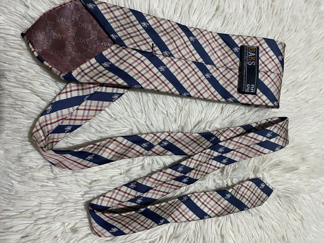 DAKS London Striped Plaid Silk Tie (Category: Ties) located in Bulacan. Submitted by rich2545 (Listing ID 1453333025, Image 3). Description: - Classic DAKS London tie - Color: Navy blue stripe with red plaid pattern - Material: 100% Silk - Features a subtle DAKS logo pattern throughout - Ideal for formal or business occasions - Adds sophistication to any outfit.