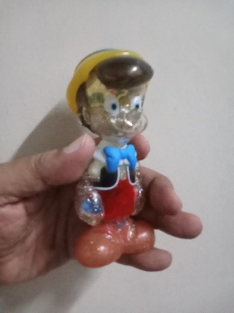 Disney Pinocchio Glitter Figurine Soap Studio (Category: Figurines & Statues) located in Marikina City. Submitted by truecat_6654e7 (Listing ID 1453252485, Image 2). Description: - Adorable glittery Pinocchio figurine - Officially licensed by Disney and made by Soap Studio - Features iconic yellow hat with blue band and red vest - Clear body filled with shimmering glitter - Ideal for Disney collectors and fans - Great display piece.