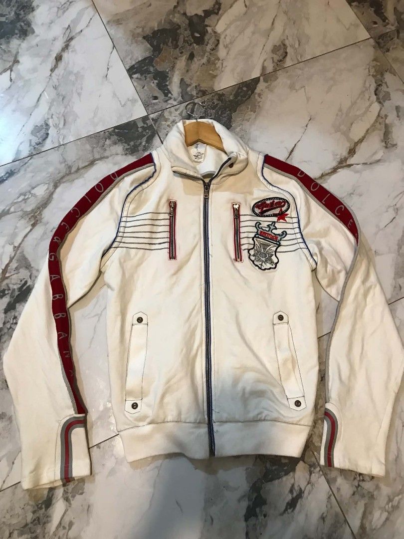 Dolce & Gabbana White Track Jacket (Category: Luxury Apparel) located in Manila. Submitted by mikeee03 (Listing ID 1453385192, Image 2). Description: - Authentic White Dolce & Gabbana Track Jacket - Eye-catching red and blue accents on sleeves and collar - Embroidered D&G patches on the chest - Convenient zippered pockets - Branded D&G zipper pull - Ideal for a stylish casual look - Negotiable - Drop offer .