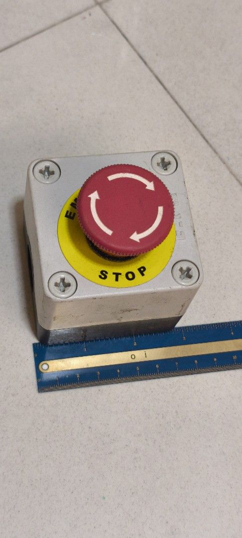 E-STOP BUTTON for machine (Category: Parts & Accessories) located in Singapore. Submitted by wholesomely (Listing ID 1453398710, Image 1). Description: - Emergency Stop Button - Features a prominent red mushroom-shaped push button - Clearly marked with 'EMERGENCY STOP' text and circular arrows - Mounted on a robust grey and black casing - Suitable for industrial or workshop safety applications.
