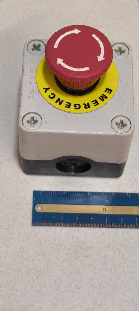 E-STOP BUTTON for machine (Category: Parts & Accessories) located in Singapore. Submitted by wholesomely (Listing ID 1453398710, Image 3). Description: - Emergency Stop Button - Features a prominent red mushroom-shaped push button - Clearly marked with 'EMERGENCY STOP' text and circular arrows - Mounted on a robust grey and black casing - Suitable for industrial or workshop safety applications.