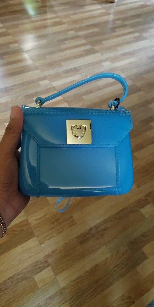 Furla Jelly Mini Bag - Blue (Category: Luxury Bags & Wallets) located in Bay. Submitted by silverhorse-59c851 (Listing ID 1453272699, Image 3). Description: - Cute blue Furla mini jelly bag - Features a gold clasp closure - Includes a detachable strap - Made in Italy - Ideal for a pop of color - Perfect size for essentials.