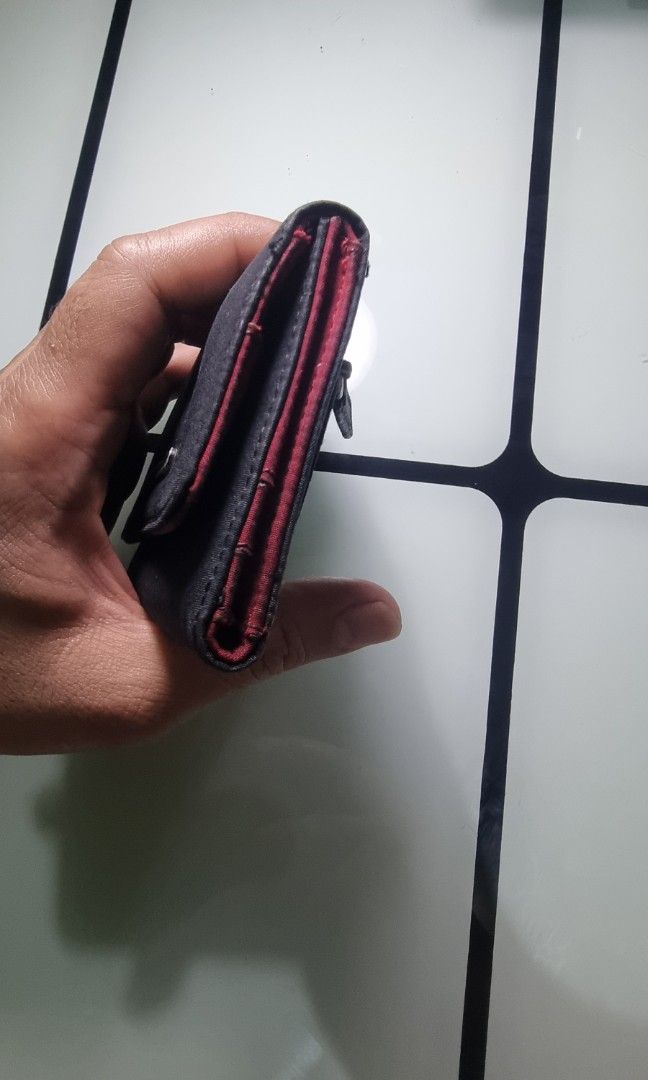 GUESS women's compact trifold wallet (Category: Wallets & Card holders) located in San Pedro. Submitted by elevens_online_thrift_shop (Listing ID 1453298517, Image 2). Description: ​Brand: GUESS ​Style: Vintage / Y2K-era flap wallet (trifold or bifold silhouette) ​Material: Black durable fabric/canvas upper with a metal logo plate on the main flap ​Features: Typically includes card slots, an ID window, a bill compartment, and a snap button closur