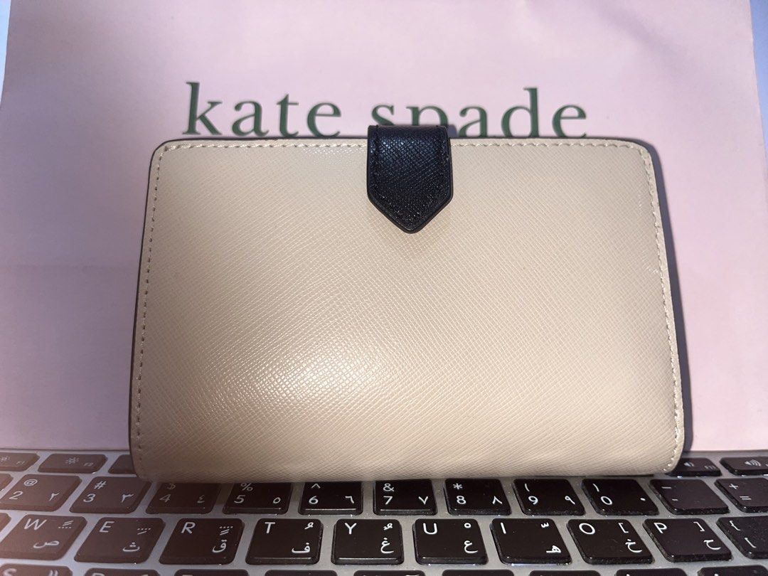 Kate Spade Bi-fold Wallet Black and Beige (Category: Luxury Bags & Wallets) located in Las Pinas. Submitted by shopperz (Listing ID 1453327277, Image 2). Description: - Brand: Original Kate Spade - Style: Bi-fold wallet - Color: Black and beige color block - Material: Saffiano leather - Closure: Snap closure - Interior: Card slots and zip pocket - Features: Great for organizing essentials, compact size - With paper bag.