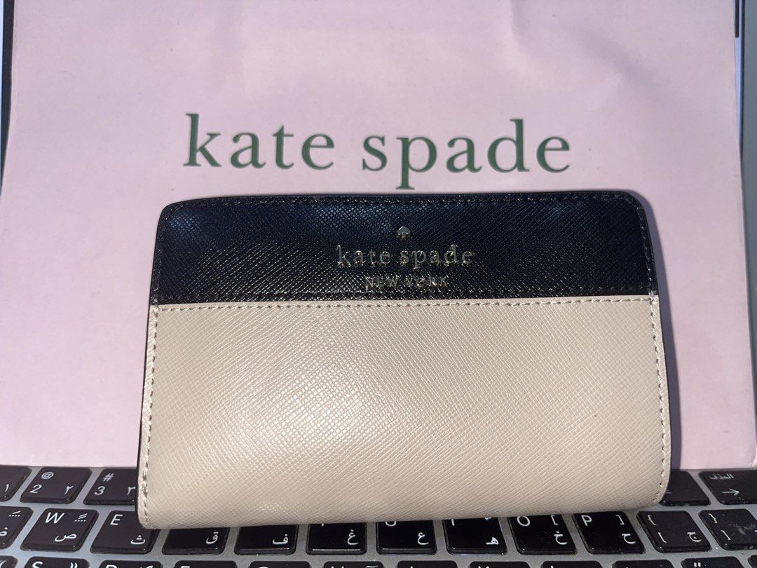 Kate Spade Bi-fold Wallet Black and Beige (Category: Luxury Bags & Wallets) located in Las Pinas. Submitted by shopperz (Listing ID 1453327277, Image 1). Description: - Brand: Original Kate Spade - Style: Bi-fold wallet - Color: Black and beige color block - Material: Saffiano leather - Closure: Snap closure - Interior: Card slots and zip pocket - Features: Great for organizing essentials, compact size - With paper bag.