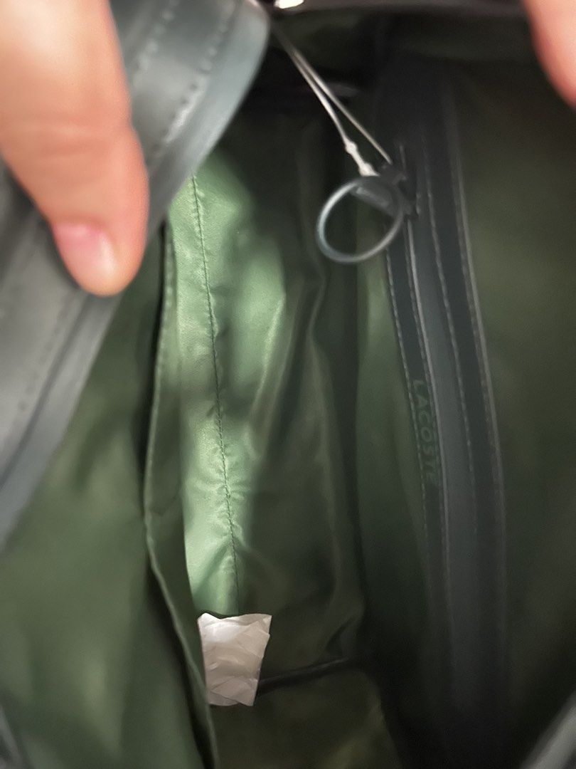 Lacoste Dark Green Leather Duffel Bag (Category: Luxury Bags & Wallets) located in Cebu City. Submitted by tagsglamor (Listing ID 1453281534, Image 3). Description: - Authentic dark green Lacoste duffel bag - Crafted from premium leather - Spacious main compartment - Convenient internal pockets for organization - Includes a detachable shoulder strap for versatile carrying - Comes with its original dust bag - Ideal for weekend trips or gym essenti