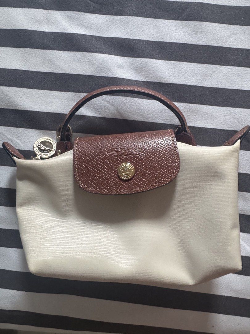 Longchamp Le Pliage Cuir Small Top Handle Bag Beige (Category: Luxury Bags & Wallets) located in Makati City. Submitted by kpmg111 (Listing ID 1453270065, Image 1). Description: Beige Longchamp Le Pliage Cuir small top Features brown leather trim and handle Secure snap button closure Comes with a small attached charm Minor faint marks on the canvas body Ideal for everyday use With strap Guaranteed authentic or money back 10x DM for inquiries.