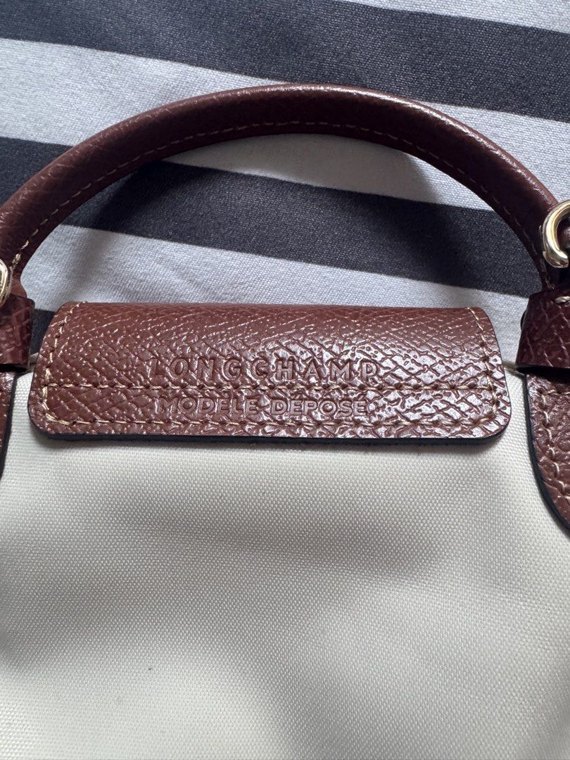 Longchamp Le Pliage Cuir Small Top Handle Bag Beige (Category: Luxury Bags & Wallets) located in Makati City. Submitted by kpmg111 (Listing ID 1453270065, Image 3). Description: Beige Longchamp Le Pliage Cuir small top Features brown leather trim and handle Secure snap button closure Comes with a small attached charm Minor faint marks on the canvas body Ideal for everyday use With strap Guaranteed authentic or money back 10x DM for inquiries.