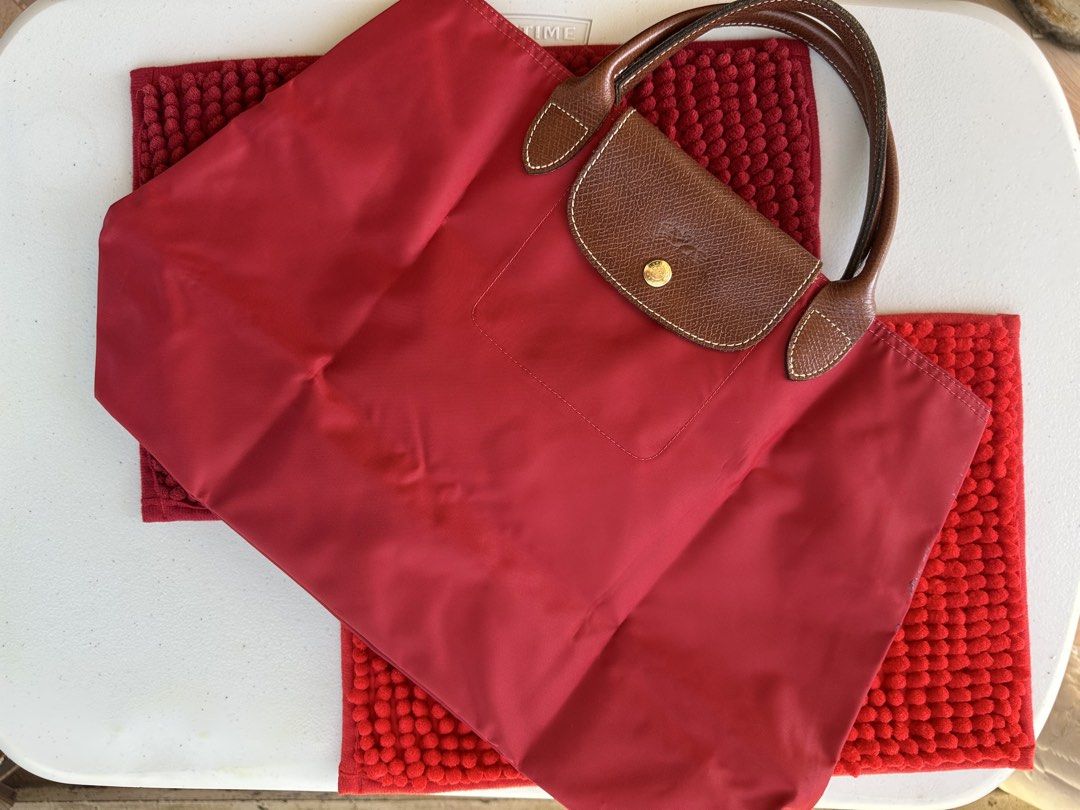 Longchamp Le Pliage Tote Bag Red (Category: Luxury Bags & Wallets) located in San Fernando. Submitted by golden_pat.d (Listing ID 1453237322, Image 2). Description: 🔸Classic Longchamp tote bag 🔸Red nylon with brown leather handles and trim 🔸Folds flat for easy storage & spacious interior 🔸 Bought from Japan 💰Price is negotiable 📍 San Fernando, Pampanga / Monumento, Caloocan ‼️RFS: Decluttering‼️.