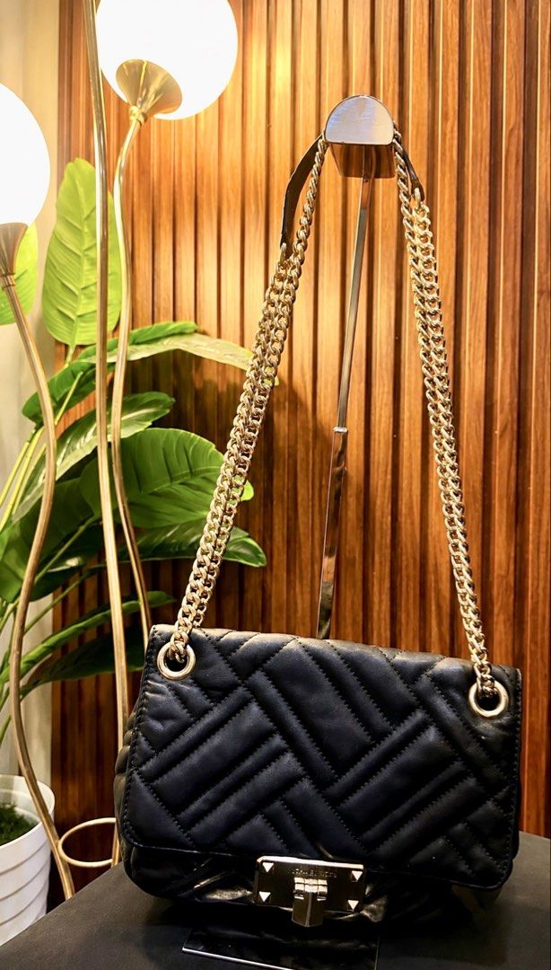 Michael Kors Black Quilted Leather Chain Shoulder Bag (Category: Luxury Bags & Wallets) located in Quezon City. Submitted by genie_in_a_closet (Listing ID 1453320153, Image 2). Description: - Pre-loved, Original - Black quilted leather shoulder bag - Gold chain strap - Secure turn-lock closure with Michael Kors branding - Versatile for day or night use - Spacious interior for essentials - Elegant gold hardware details - This is pre-loved, used bu