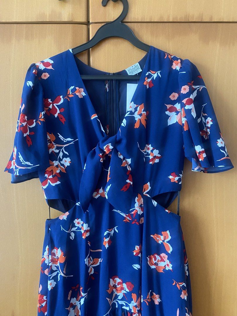 Missing Piece (Category: Dresses) located in Singapore. Submitted by esther21 (Listing ID 1453299541, Image 2). Description: - Brand: The Missing Piece - Size: S (UK 8 / EU 36 / US 4) PTP 41cm Waist 34cm Length 135cm - Color: Navy blue with floral print (red & orange accents) - Style: Midi dress with V-neck, tie-front detail, and waist cut-outs - Condition: Brand new with tags - Perfect for casual outings or events.