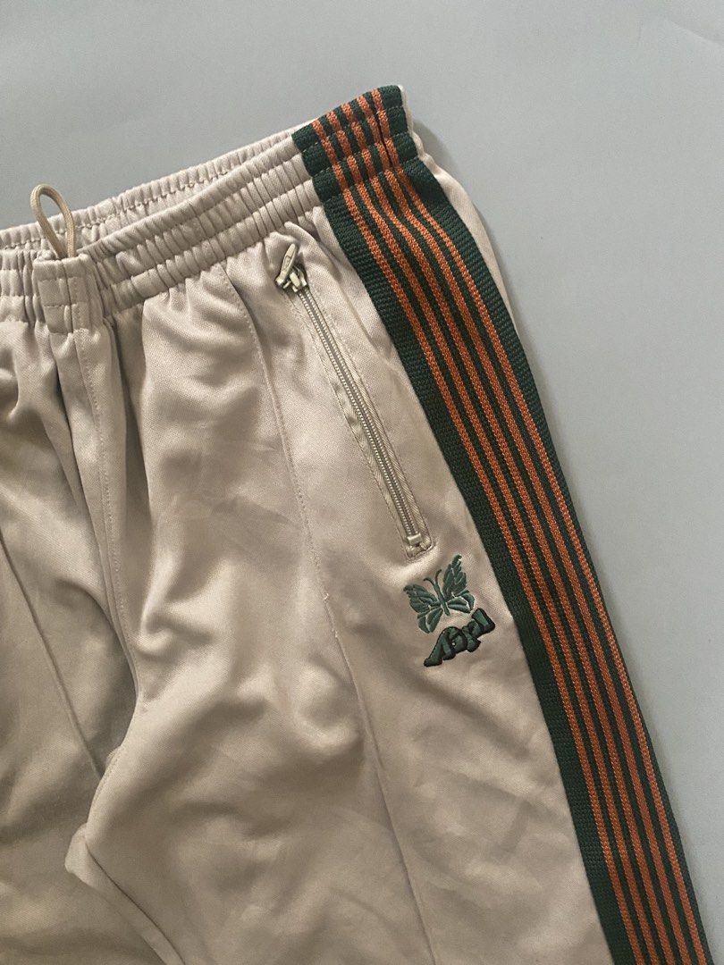 NEEDLES X AIPL (Category: Joggers) located in Angeles City. Submitted by good_catchv3 (Listing ID 1453257205, Image 2). Description: Needles x AIPL track pants in beige with a green and orange side stripe. WAISTLINE FREE SIZE 30-38 LENGTH 39.5 LEG OPEN 10.