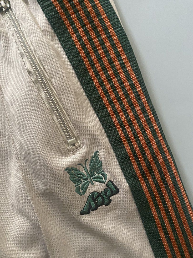 NEEDLES X AIPL (Category: Joggers) located in Angeles City. Submitted by good_catchv3 (Listing ID 1453257205, Image 3). Description: Needles x AIPL track pants in beige with a green and orange side stripe. WAISTLINE FREE SIZE 30-38 LENGTH 39.5 LEG OPEN 10.