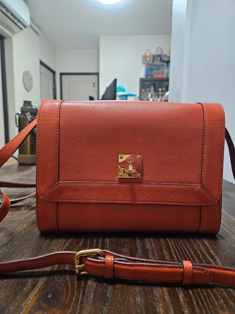 Orange Leather Handbag with Gold Clasp (Category: Luxury Bags & Wallets) located in Taguig. Submitted by m_lim (Listing ID 1453286170, Image 1). Description: - Vibrant orange leather handbag - Secure gold clasp closure on the front - Interior zippered compartment for valuables - Adjustable strap with a gold buckle for customized fit - Versatile for everyday wear or special occasions - Spacious interior to hold all your essentials.