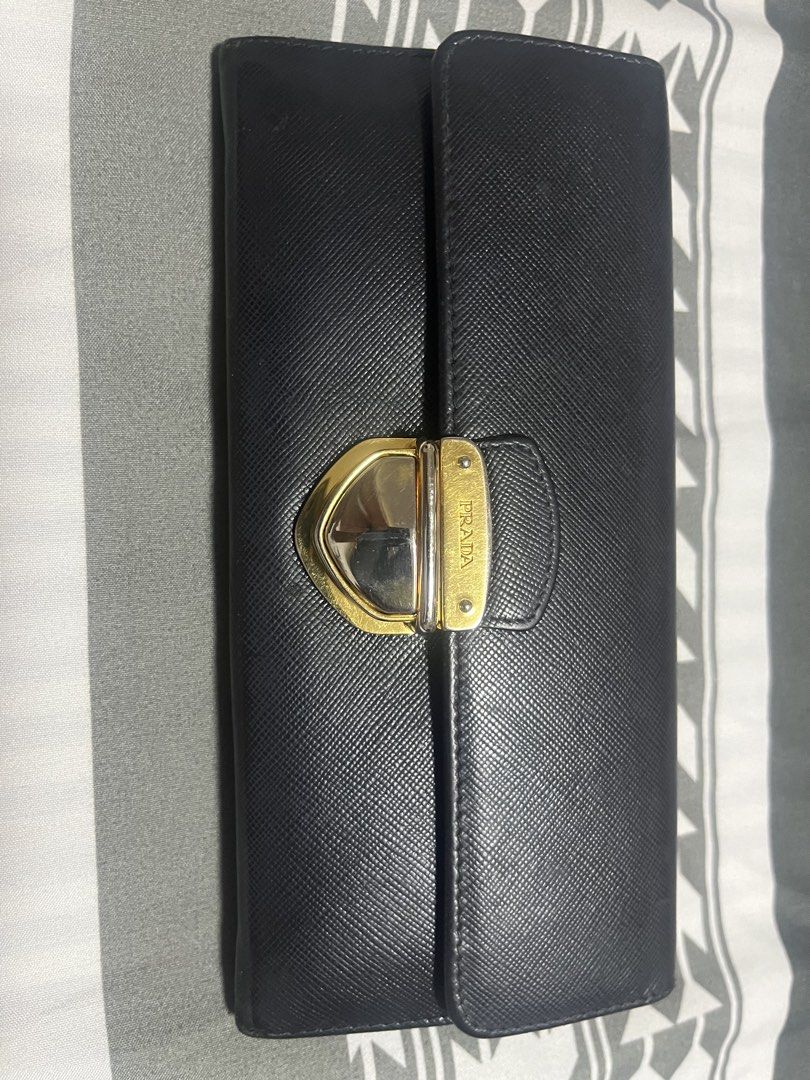 Prada Black Saffiano Leather Long Wallet (Category: Luxury Bags & Wallets) located in Manila. Submitted by yangcastro47434 (Listing ID 1453313590, Image 2). Description: - Authentic Prada wallet in classic black Saffiano leather. - Features a secure gold-tone clasp closure. - Ample card slots and a zippered compartment for organization. - Interior is clean and well-maintained. - Shows minor signs of wear on hardware and edges, consistent with nor
