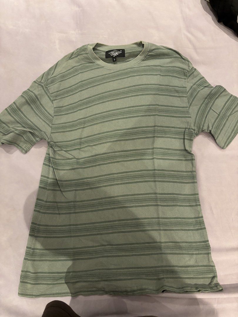 Sage Green Striped T-shirt (Category: Shirts) located in Quezon City. Submitted by digo_bengzon (Listing ID 1453288292, Image 1). Description: - Classic short-sleeved t-shirt - Stylish sage green with darker green horizontal stripes - Comfortable fabric with a subtle texture - Perfect for casual, everyday outfits - Tag visible on the front.