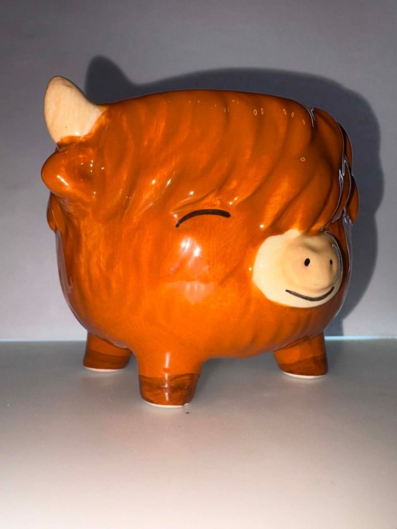 Sass & Belle Highland Cow Ceramic Holder (Category: Coffee & Tea Tableware) located in Caloocan City. Submitted by rabbithole2026 (Listing ID 1453376843, Image 2). Description: Adorable ceramic holder featuring a smiling Highland cow with shaggy orange-brown hair, little horns, and cute sculpted feet. Perfect as a planter, pen holder, desk organizer, makeup brush holder, or decorative accent. Features: Brand: Sass & Belle Highland cow design Glos