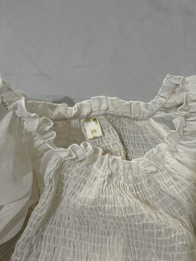 Sheer Off-Shoulder Smocked Crop Top White (Category: Others Tops) located in Pasig City. Submitted by polyhedra_ (Listing ID 1453307060, Image 3). Description: - XS to S - Sheer off-shoulder design - Smocked bodice for a flattering fit - Billowy long sleeves with elastic cuffs - Cropped style - Versatile for dressing up or down - See small cabinet marks (can be removed by laundry).