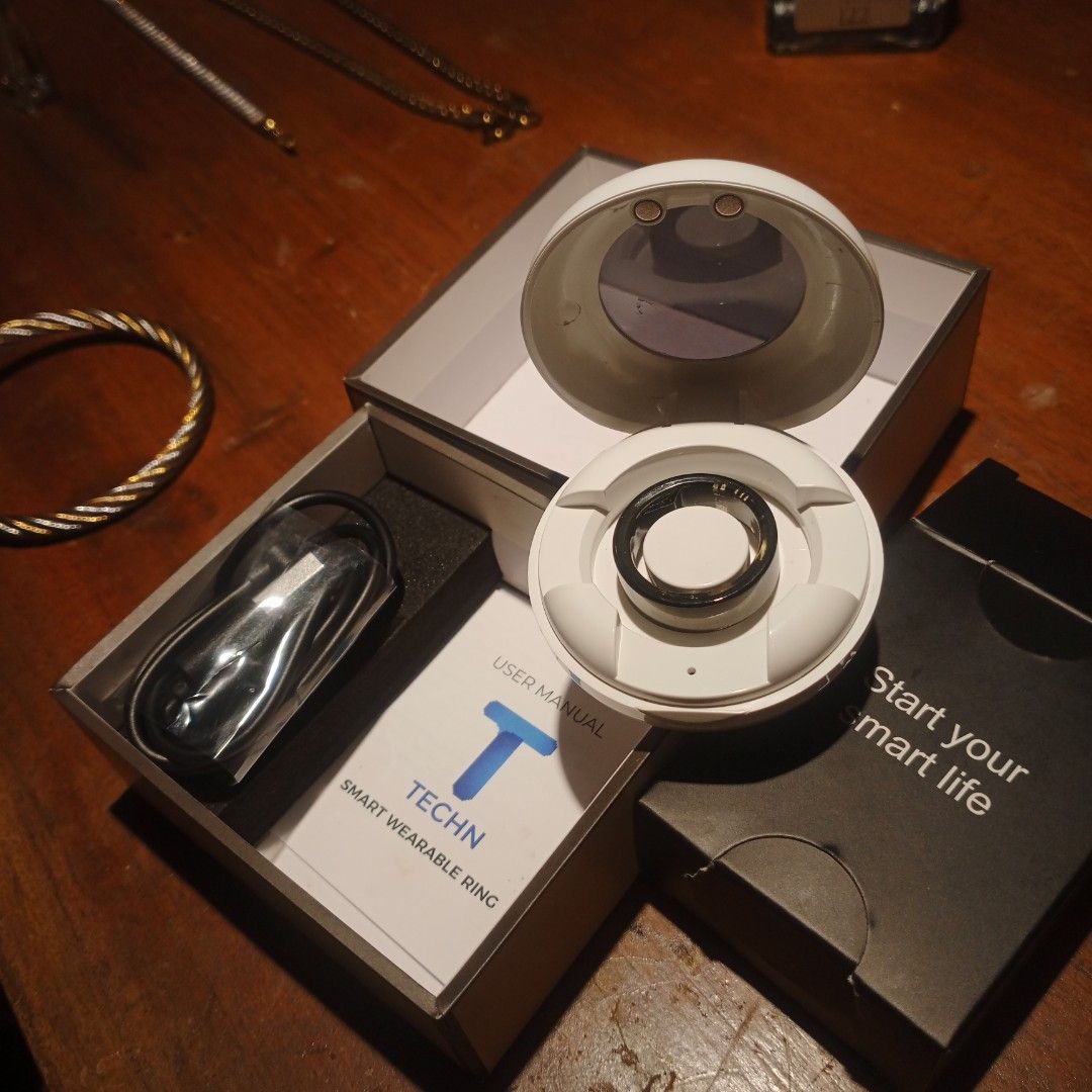 Smart Ring Tracker (Category: Wearables & Smart Watches) located in Manila. Submitted by valdez_bryan369 (Listing ID 1453377909, Image 3). Description: This TECHN smart wearable ring comes with a circular charging dock.It is designed to track health metrics such as heart rate, blood pressure, and blood oxygen levels.The ring is constructed from lightweight materials, typically stainless steel, and is generally waterproof.