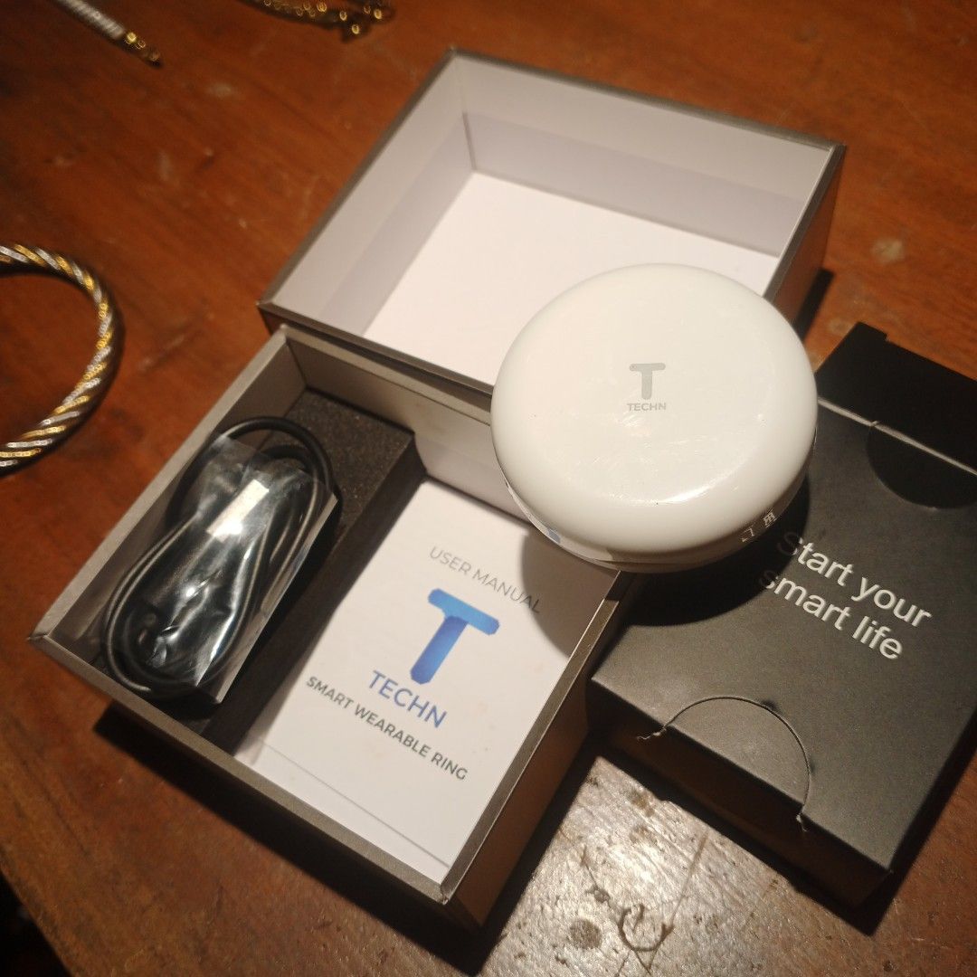 Smart Ring Tracker (Category: Wearables & Smart Watches) located in Manila. Submitted by valdez_bryan369 (Listing ID 1453377909, Image 2). Description: This TECHN smart wearable ring comes with a circular charging dock.It is designed to track health metrics such as heart rate, blood pressure, and blood oxygen levels.The ring is constructed from lightweight materials, typically stainless steel, and is generally waterproof.