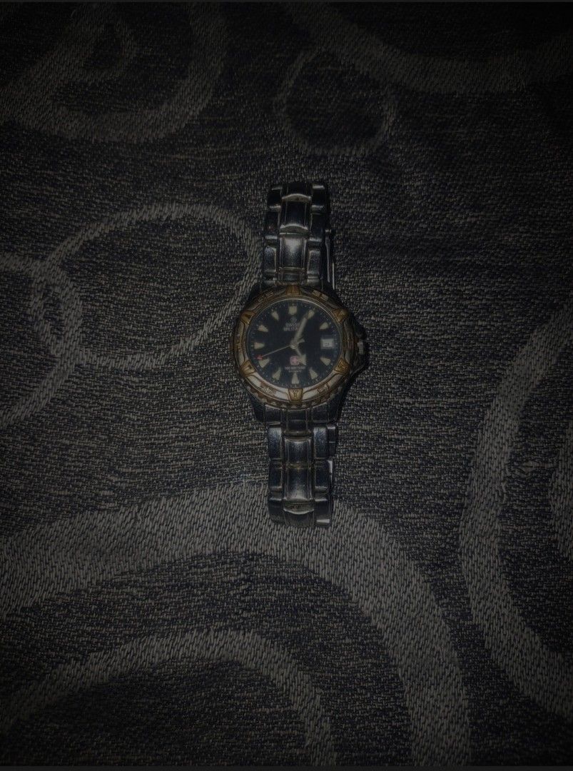Swiss Military 100M Automatic Diver-Style Watch (Category: Men's Watches) located in Batac City. Submitted by silvercrystal_fd03a9 (Listing ID 1453395979, Image 1). Description: Vintage Swiss Military automatic watch featuring a dark black dial, luminous indices, date window at 3 o'clock, and a two-tone accent bezel with stainless steel bracelet. Classic rugged military design built for daily wear. ​Brand: Swiss Military ​Movement: Automatic ​Wat