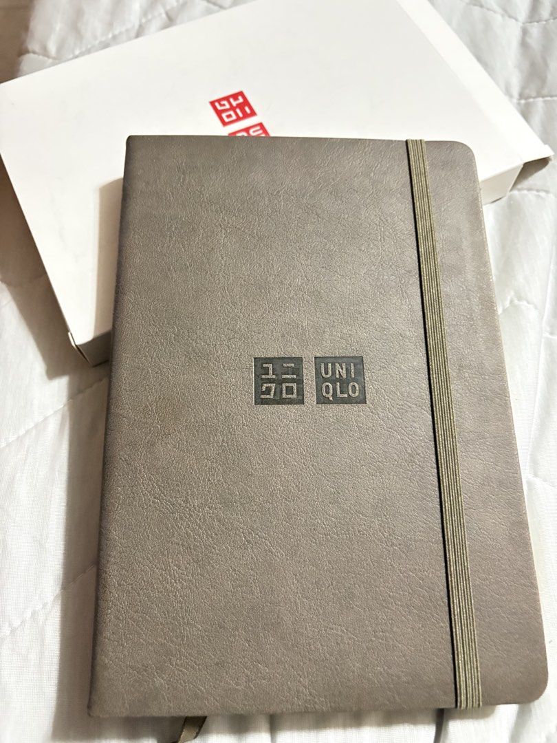Uniqlo Notebook Undated Planner (Category: Stationery & School Supplies) located in Malabon City. Submitted by jinisells (Listing ID 1453373704, Image 3). Description: - Uniqlo Notebook - Includes original box - Features a weekly planner layout on one side - Dotted pages on the other side - Secure elastic band closure - Ideal for daily planning and journaling 200 each Available in blue and brown.