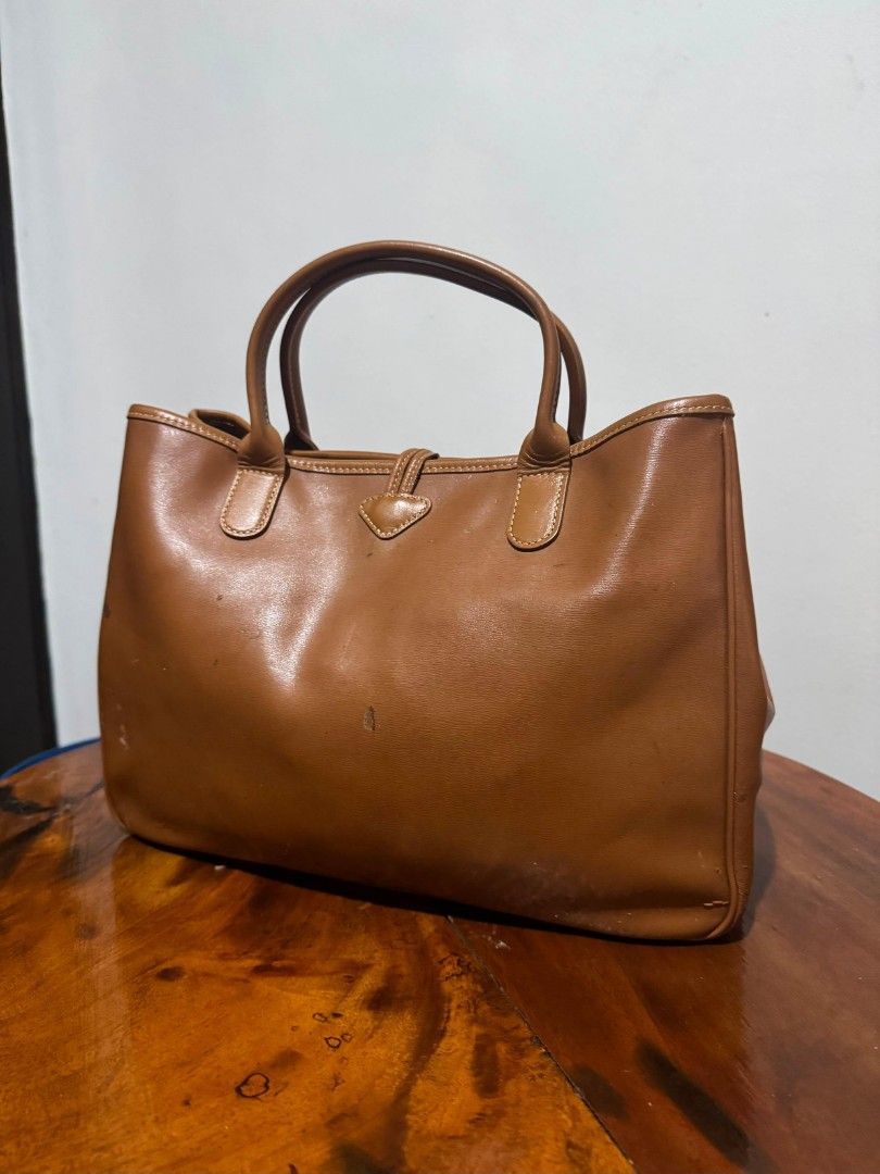 ORIGINAL VINTAGE COGNAC LONGCHAMP ROSEAU (Category: Luxury Bags & Wallets) located in Manila. Submitted by lexstrozzi (Listing ID 1453338555, Image 3). Description: VINTAGE LONGCHAMP ROSEAU TOP-HANDLE 100% Authentic comes with the original Longchamp authenticity paper cards Material: 100% Premium smooth tan leather (thick and highly structured) Closure: Signature gold bamboo toggle mechanism (snaps tightly, zero rust) Interior: Clean internal com