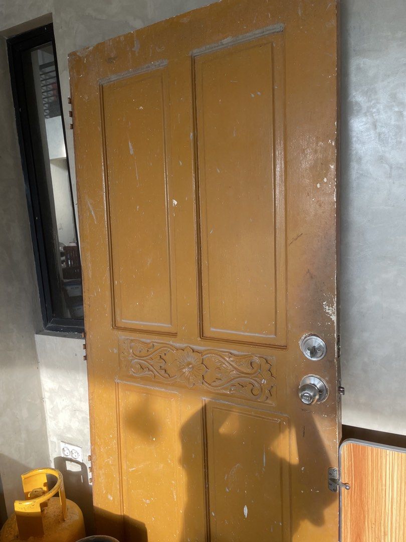 Wooden Door with Lockset and Handle (Category: Locks, Doors & Gates) located in Manila. Submitted by malyniphon86147 (Listing ID 1453408973, Image 3). Description: - Solid wooden door - Attractive yellow-brown paint finish - Four distinct panels - Decorative carving on the middle section - Includes lockset and doorknob - Shows some signs of wear and tear (paint and edges) - Ready for immediate use or a creative renovation project.