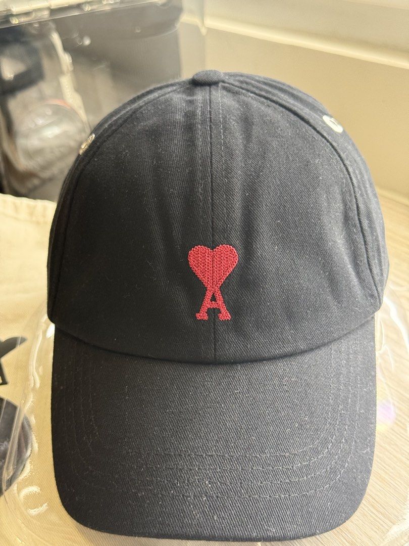 AMI Paris Ami de Coeur Cap Black (Category: Caps & Hats) located in San Fernando. Submitted by archvst.selects (Listing ID 1456634304, Image 2). Description: - Black AMI Paris cap - Features iconic Ami de Coeur logo embroidery - Adjustable strap for a custom fit - Comes with original dust bag and small black disc - Made in Portugal.