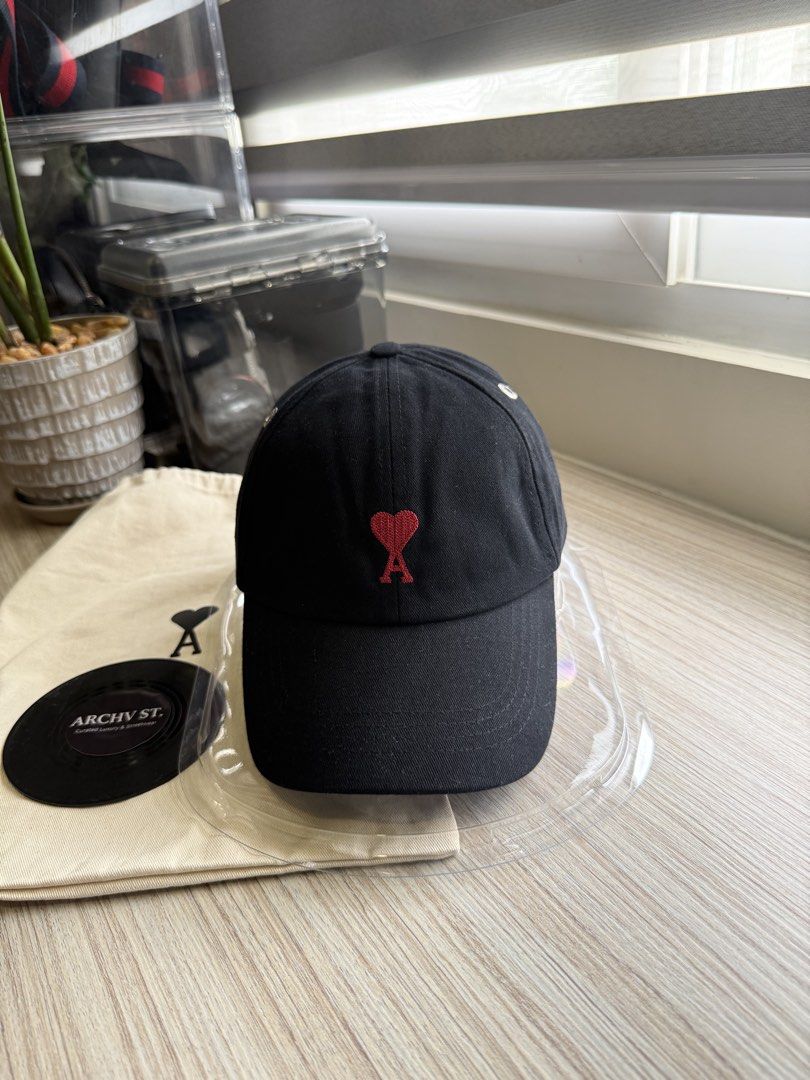 AMI Paris Ami de Coeur Cap Black (Category: Caps & Hats) located in San Fernando. Submitted by archvst.selects (Listing ID 1456634304, Image 1). Description: - Black AMI Paris cap - Features iconic Ami de Coeur logo embroidery - Adjustable strap for a custom fit - Comes with original dust bag and small black disc - Made in Portugal.
