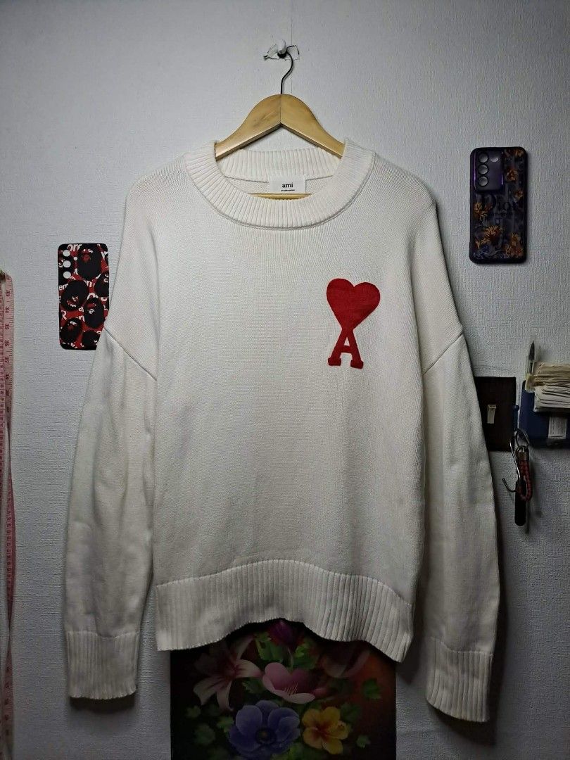 AMI PARIS KNITTED HEART LOGO (Category: Luxury Apparel) located in Manila. Submitted by yaseen_73 (Listing ID 1456722250, Image 1). Description: Off-white wool Ami de Coeur crewneck sweater from Ami Paris features the brand's signature red intarsia-knitted heart logo on the chest Made in Tunisia Wearing Size : M on Tag Dimensions : W24½ x L26½ Color Rate : 10/10 📌Needs Re - Wash No Minor/Major Issue Nearly New Condition P.S. - This Item is Off /