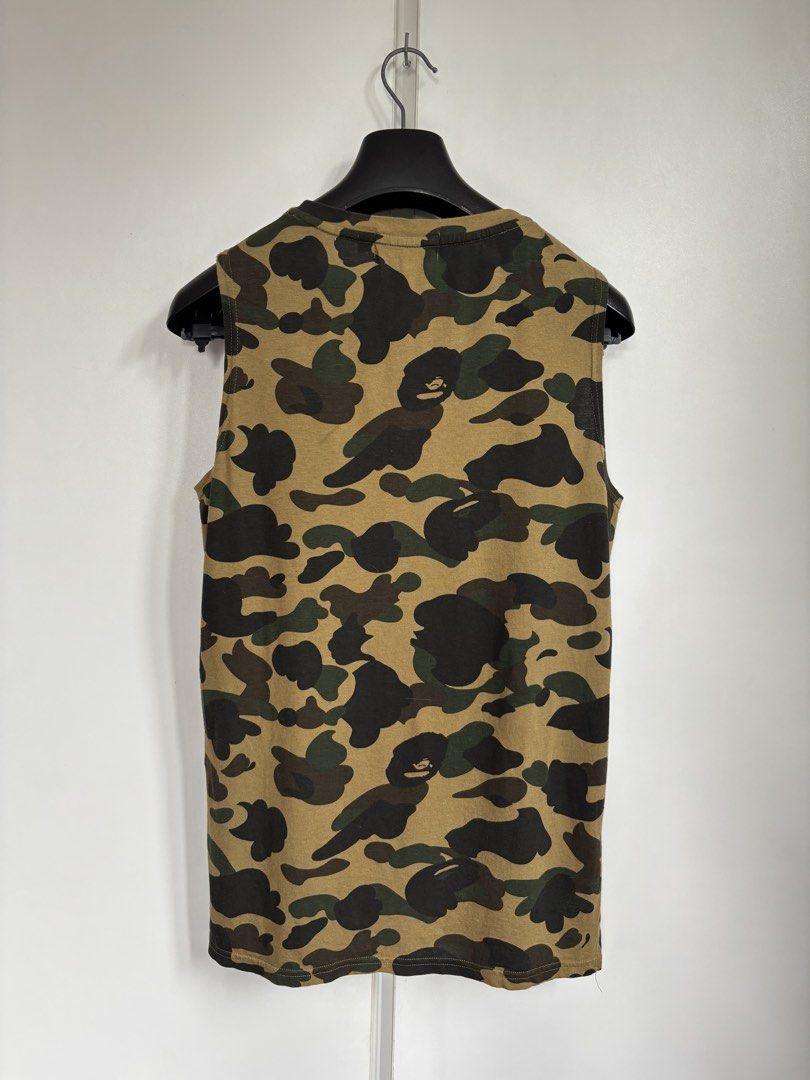 BAPE A Bathing Ape 1st Camo Tank Top (Category: Tshirts & Polo Shirts ) located in Paranaque City. Submitted by grailonious (Listing ID 1456754796, Image 2). Description: Dimensions posted. Like new condition - Classic BAPE camo print - V-neck design - Made in Japan - Material: 50% Cotton, 50% Rayon - Tagged Size: XS - Adjacent to neighborhood kaws and originalfake.