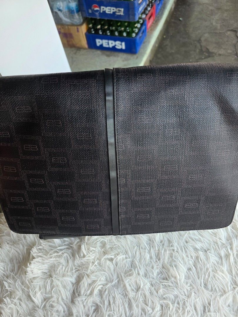Black Monogram Messenger Bag (Category: Luxury Bags & Wallets) located in Lemery. Submitted by venus23 (Listing ID 1456714229, Image 3). Description: - Black messenger bag with repeating monogram pattern - Main compartment with internal pockets - Additional zippered section for secure storage - Adjustable strap for comfortable carrying - Ideal for daily use or travel - Shows some signs of wear on leather accents.
