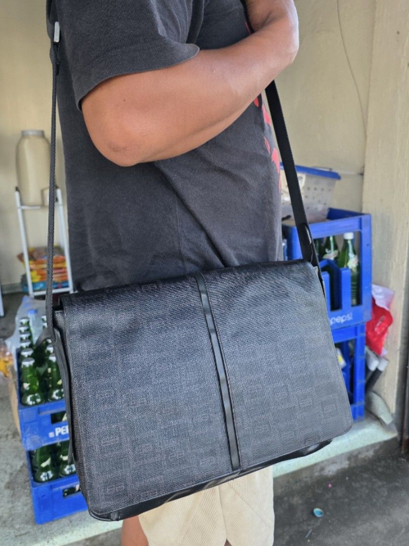 Black Monogram Messenger Bag (Category: Luxury Bags & Wallets) located in Lemery. Submitted by venus23 (Listing ID 1456714229, Image 2). Description: - Black messenger bag with repeating monogram pattern - Main compartment with internal pockets - Additional zippered section for secure storage - Adjustable strap for comfortable carrying - Ideal for daily use or travel - Shows some signs of wear on leather accents.