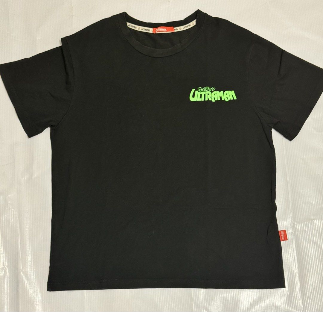 Black Ultraman Graphic T-Shirt (Category: Tshirts & Polo Shirts ) located in Quezon City. Submitted by domsselections2 (Listing ID 1456762458, Image 1). Description: - Cool black t-shirt with Ultraman graphic on the front. - Back features a fun print of Ultraman battling a monster. - Text on back reads: 'Can't go to school, empty stomach'. - Made from comfortable cotton material. - Ideal for fans of Ultraman and Japanese monster movies. Dimes: 20