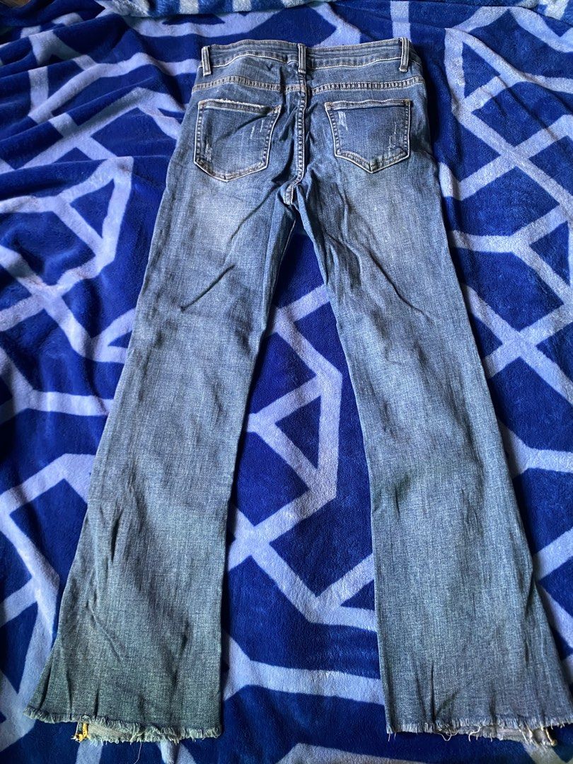Blue Flared Jeans with Side Zips (Category: Jeans) located in Caloocan City. Submitted by lienzonius (Listing ID 1456679209, Image 3). Description: - Trendy blue denim jeans with a stylish flared leg - Features a classic zip and button front closure - Eye-catching distressed details and small rips on the legs - Unique raw, frayed hem edges for an edgy look - Convenient side zippers for added detail and fit - Ideal for creating a cool, casual outf