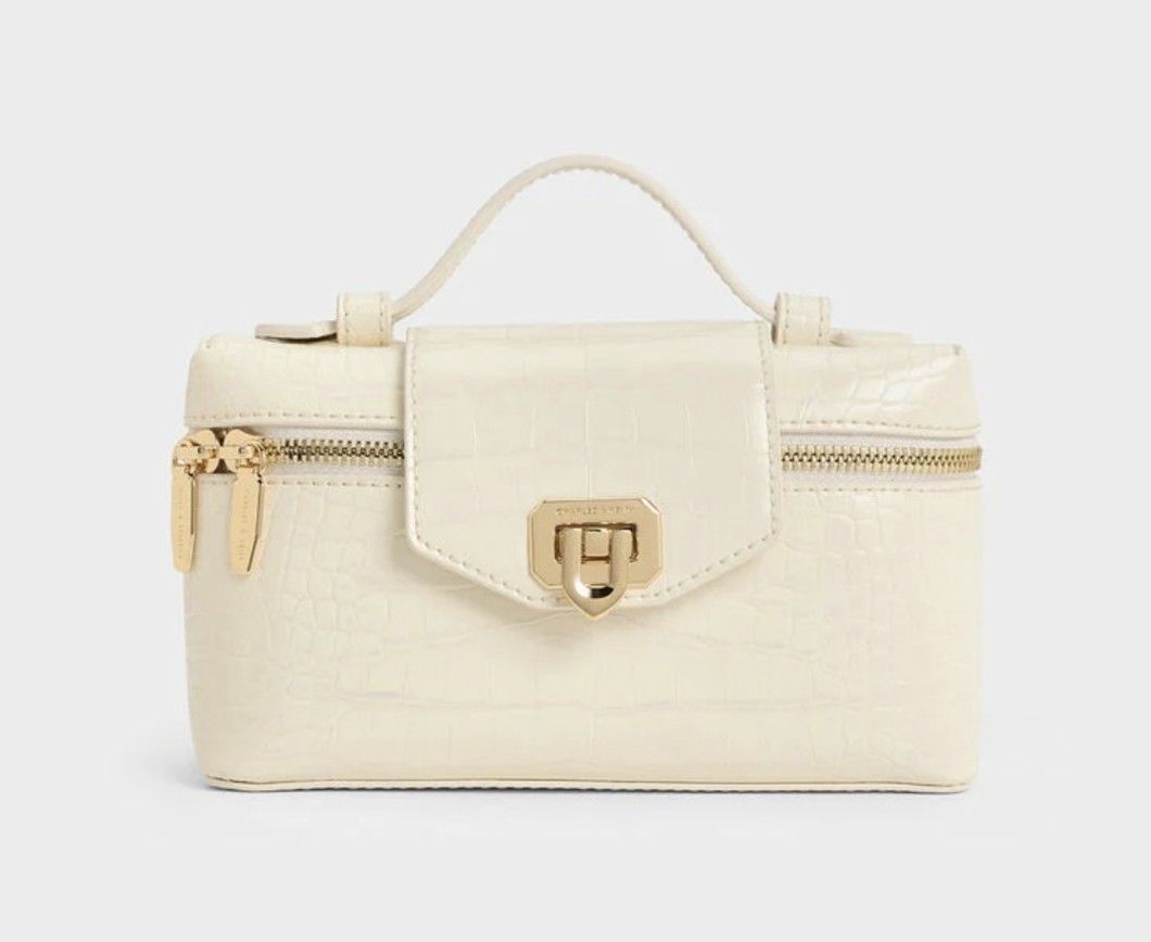 Charles & Keith White Croc Vanity Bag with Gold Hardware (Category: Cross-body Bags) located in Cavite. Submitted by house_of_tabitha (Listing ID 1456626085, Image 2). Description: - White croc-embossed vanity bag - Brand: Charles & Keith - Gold hardware - Secure clasp closure - Top handle - Detachable shoulder strap - Ideal for makeup or small essentials - Clean and chic design.