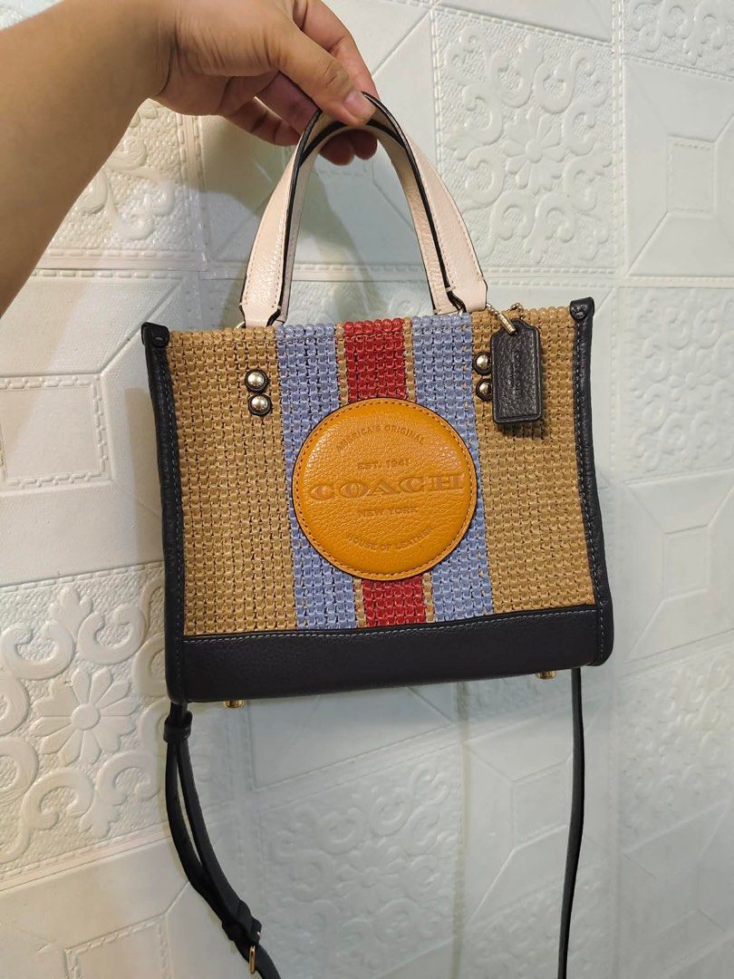 Coach Straw Tote Bag with Leather Trim (Category: Luxury Bags & Wallets) located in Bugallon. Submitted by ramezekiel14212 (Listing ID 1456748760, Image 1). Description: - Cute Coach tote bag - Woven straw body with blue and red stripes - Leather trim and handles - Classic Coach circular logo patch - Detachable crossbody strap included - Ideal for summer outings.