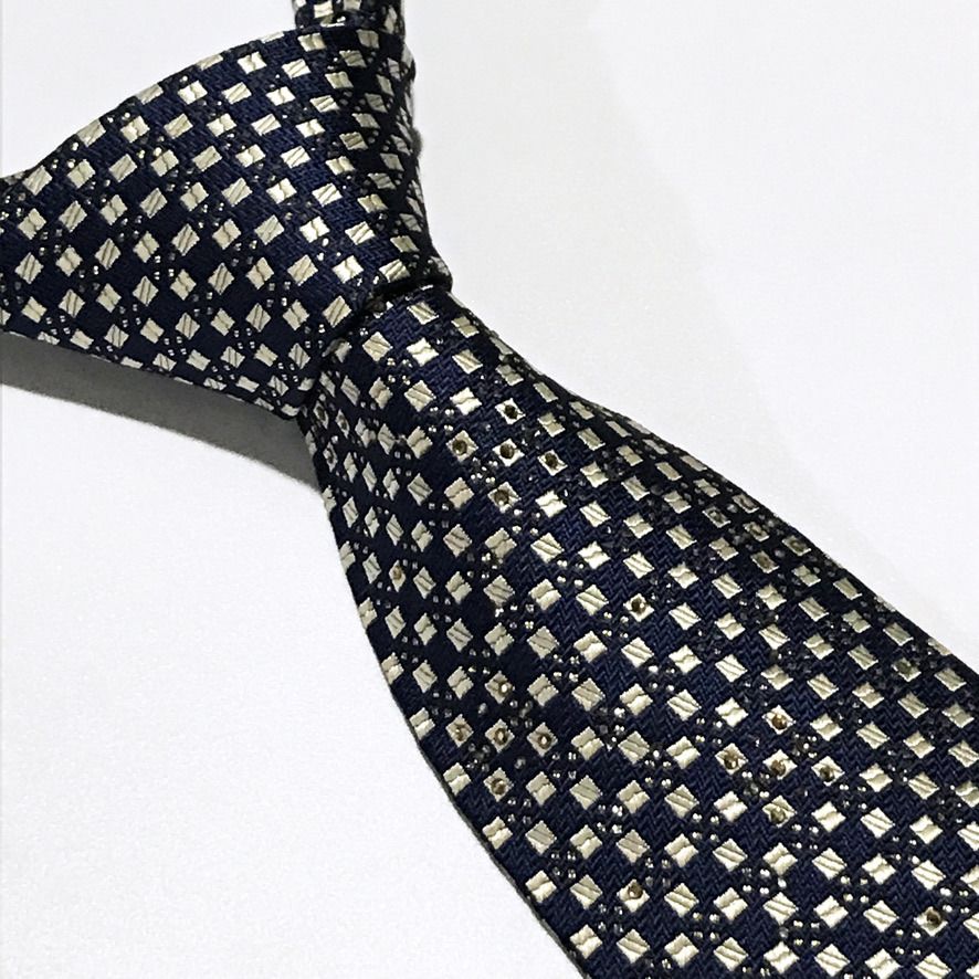 Daniel Hechter Embellished Jacquard Geometric Neck Tie (Category: Ties) located in Taguig. Submitted by retrogaze (Listing ID 1456628323, Image 1). Description: This silk-poly blend necktie by Daniel Hechter features a deep navy blue base crafted with an intricate jacquard-woven texture. The body is detailed with a structured geometric grid pattern in pale silver-gold accents, elevated by subtle rhinestone embellishments scattered across the uppe