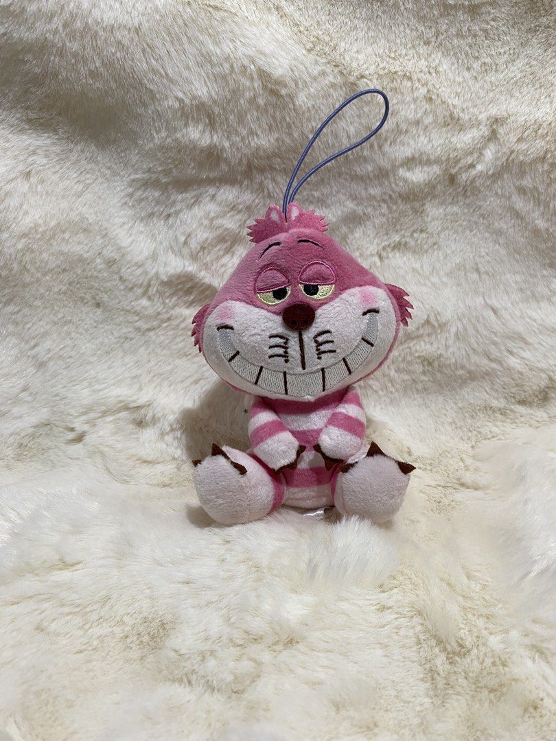 Disney Cheshire Cat Plush charm Keychain (Category: Plushies & Soft Toys) located in Kalibo. Submitted by ollie_stuffshop (Listing ID 1456629452, Image 1). Description: Before you send your inquiries: ❗️Last Price is already posted ❗️Manage your expectations, WYSIWYG ❗️May need washing ❗️Shipping day is every Sunday - Adorable Cheshire Cat plush toy - Features iconic pink and white stripes - Includes a convenient loop for hanging - Ideal for atta
