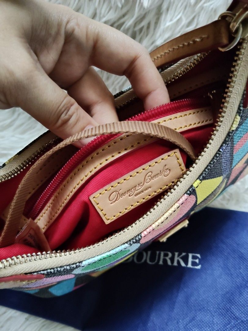 Dooney & Bourke Multi-Color Pattern Shoulder Bag (Category: Luxury Bags & Wallets) located in Iba. Submitted by royalgemini (Listing ID 1456657436, Image 2). Description: - Cute Dooney & Bourke shoulder bag - Fun, colorful geometric pattern with letters and circles - Genuine leather trim and strap - Secure zipper closure - Multiple interior compartments for organization - Comes with original dust bag - Ideal for everyday use.