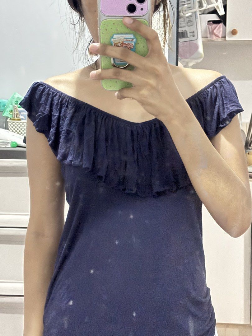 Juicy Couture Navy Blue Ruffle Off-Shoulder Top (Category: Blouses) located in Binan City. Submitted by byhiraeth (Listing ID 1456764034, Image 1). Description: - Juicy Couture navy blue off-shoulder top - Size: Medium (M) - Features cute ruffle details on neckline and sleeves - Made from soft and flowy material - Perfect for dressing up or down.